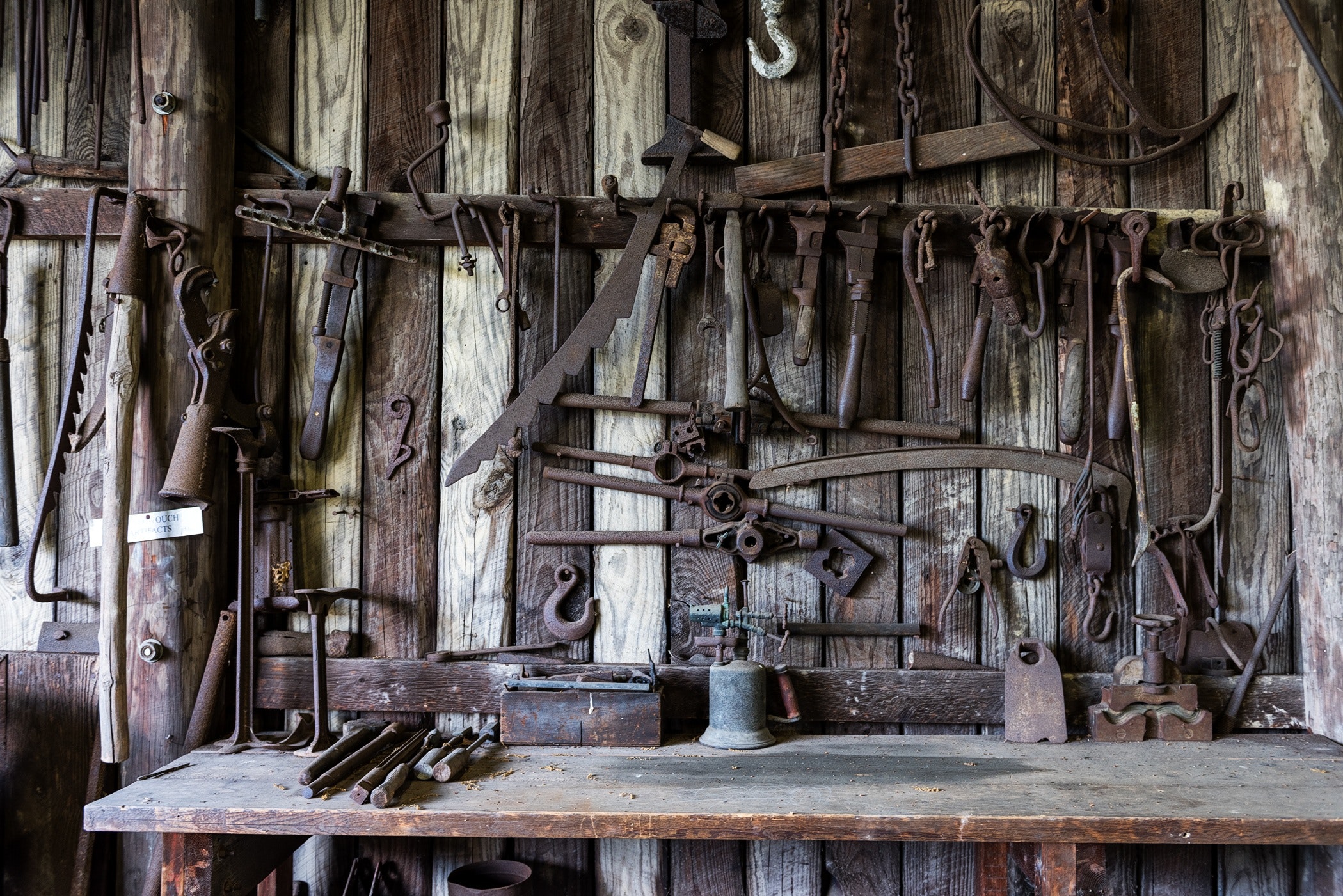 Посудный кустарь. Старинные инструменты. Старинная кузница. Старинный кузнечный инструмент. Старинная мастерская.