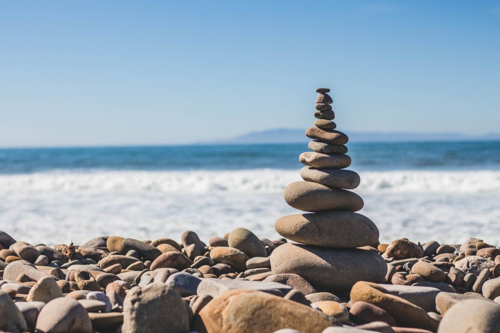 A stack of pebbles, or a rock cairn with an ocean backdrop