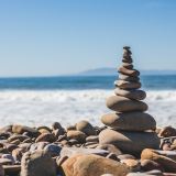 A stack of pebbles, or a rock cairn with an ocean backdrop