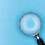 Magnifying glass against a blue background