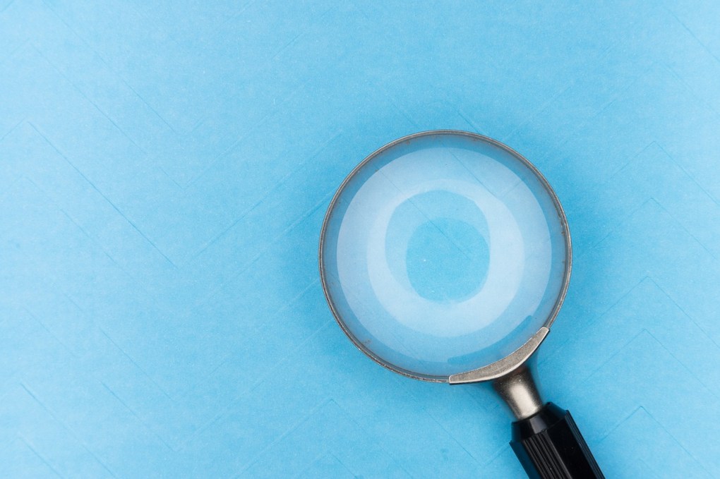 Magnifying glass against a blue background